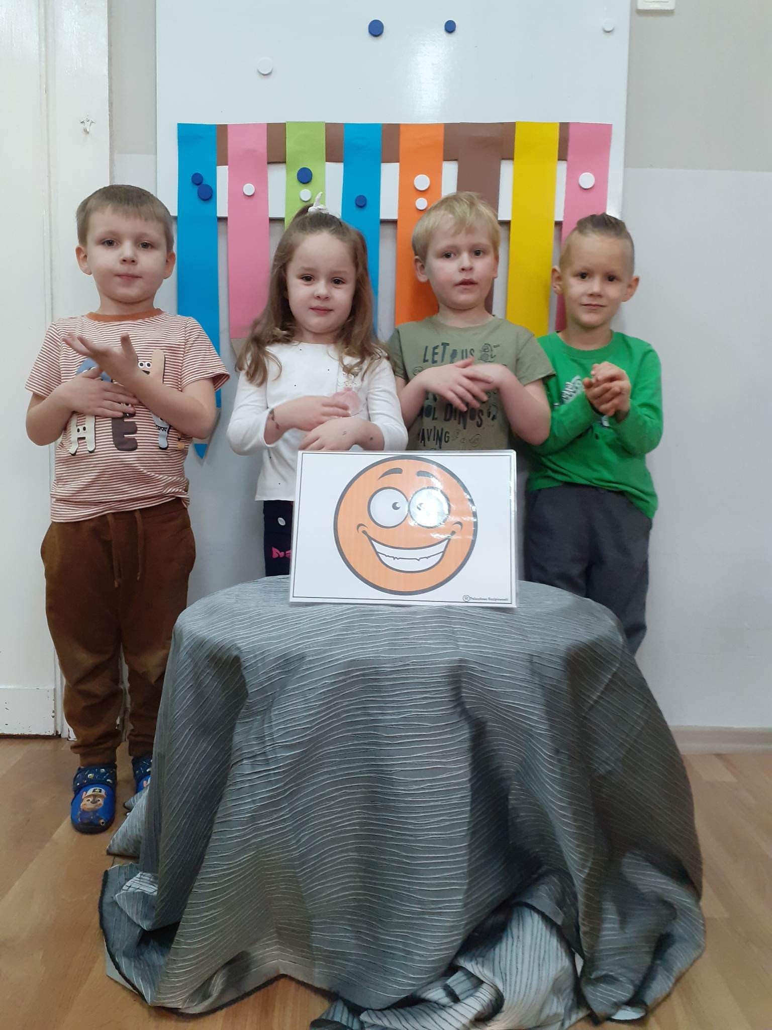 Dzieci pokazują szczęście w języku migowym.